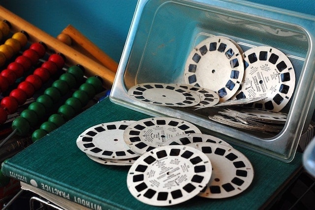 A box full of vintage view master reels, reminiscent of the days when these little discs would provide hours of entertainment, displaying iconic moments in 3D