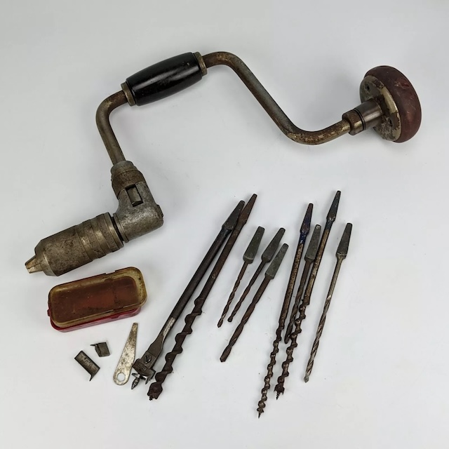 Tools of the trade: a hand drill brace along with a variety of vintage bits, used for precision and skill in every turn