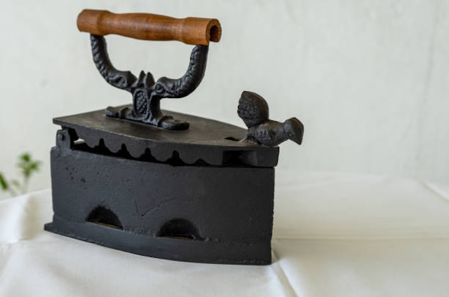 With its ornate handle, this iron not only performed its duty but also carried an elegant design, often reflecting craftsmanship from the time.