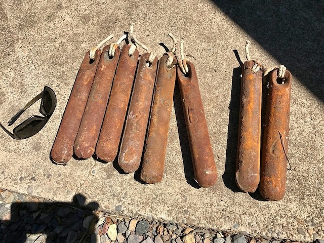 A collection of window sash weights from the early 20th century, each one telling the story of homes from the past where they ensured smooth window operation.