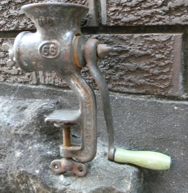 This weathered antique meat mincer with a well-worn handle still holds the charm of the bygone era when manual labor brought flavor to every meal.