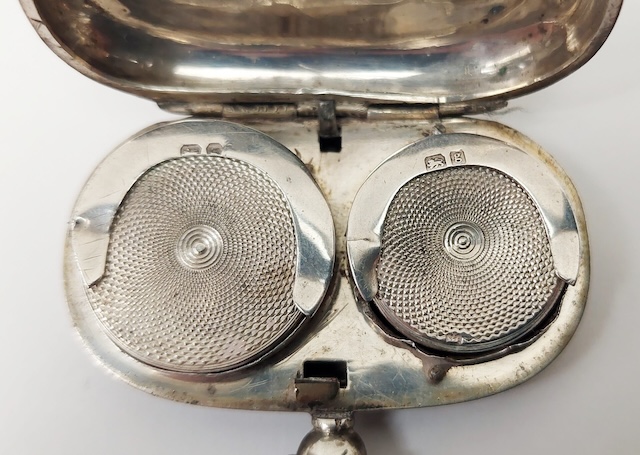 Close-up of an antique silver holder with beautifully crafted lids, each designed to protect the coins within.