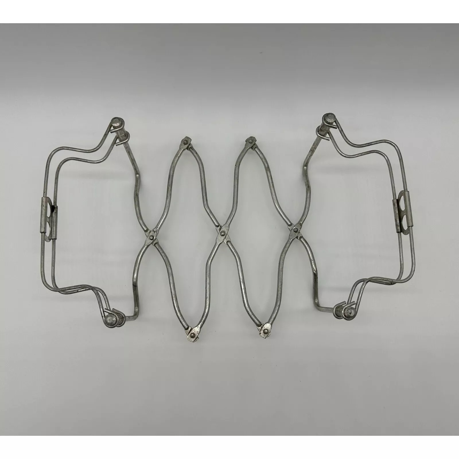 A top view of the vintage casserole caddy trivet, displaying its intricate wire design