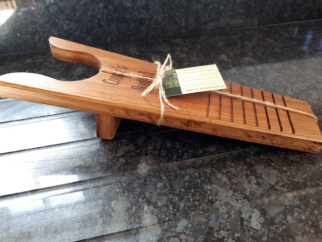 A handcrafted wooden boot jack tied with rustic string, ready for use or display