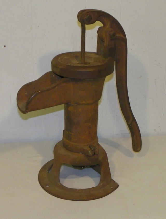 The weathered surface of this Fairbury hand pitcher pump tells a story of countless mornings spent drawing fresh water