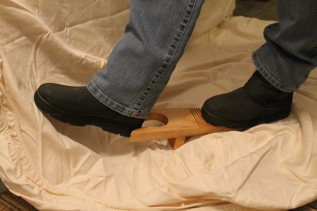 Another angle of the wooden boot jack in action, showing how it saves both time and effort when removing footwear