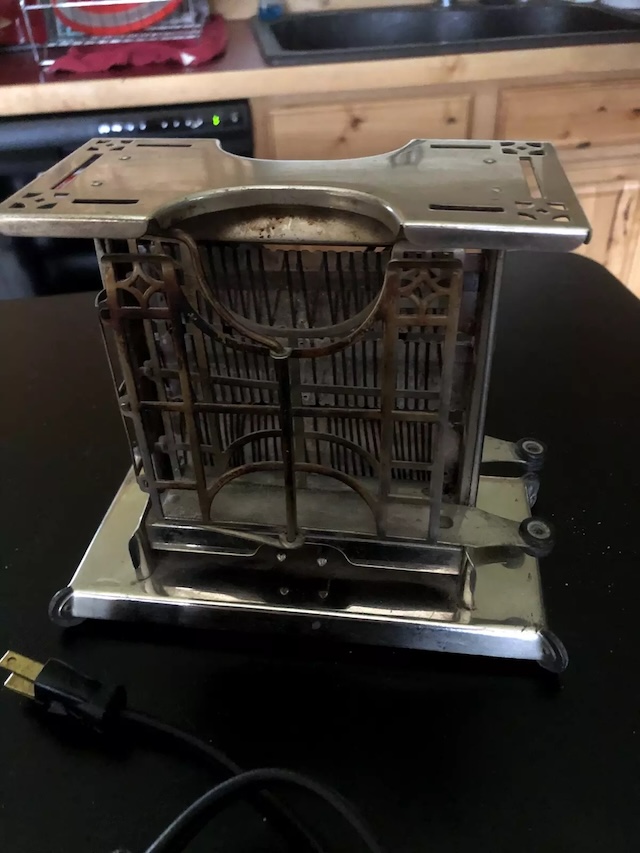 A well-preserved vintage toaster that still holds the charm of the past, complete with its original electric cord and metal frame.