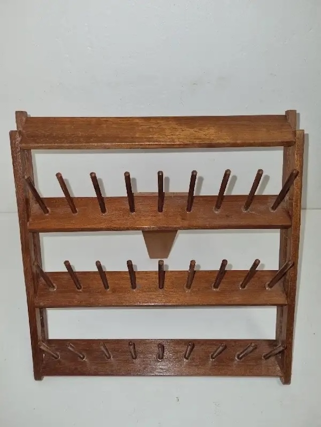 A compact, rustic vintage thread spool holder with minimalist appeal, offering practical storage for sewing enthusiasts