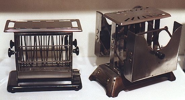 A pair of vintage toasters side by side, representing different designs from an era when kitchen technology was just beginning to take shape.