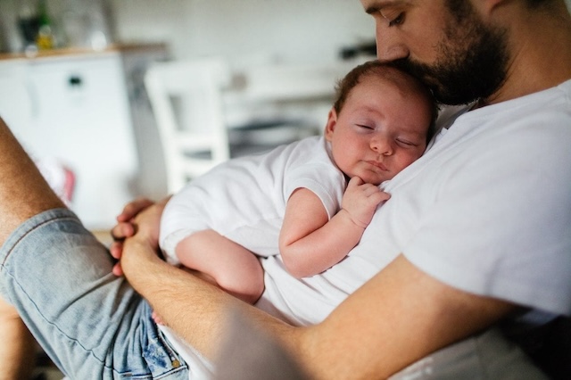 The tender embrace of a father holding his newborn child—a moment of pure love amidst a time of uncertainty