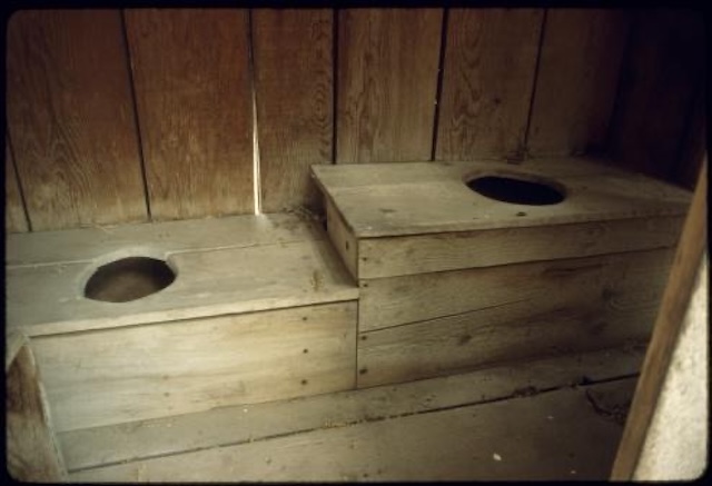 A two-seat pit toilet, offering a glimpse into a bygone era where these shared spaces were part of daily rural life