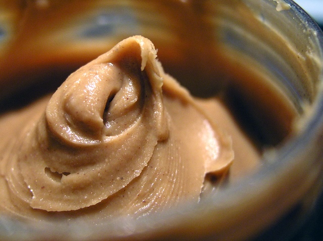 A close-up of creamy peanut butter. Fans of pantry storage love its soft, easy-to-spread texture, but is it worth the potential risk of spoilage?