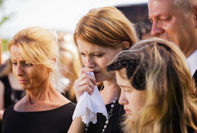 A family gathers in sorrow, grieving the death of a beloved son, as they try to find peace amidst the heartache