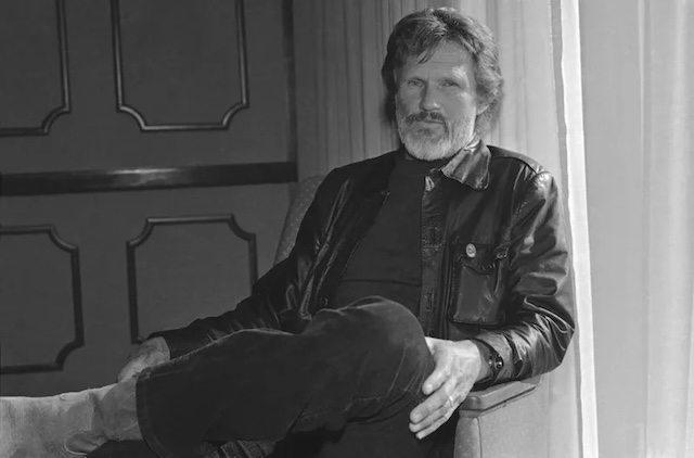 Kris Kristofferson reclining in a chair, a quiet moment that contrasts with the larger-than-life roles he played in both music and film