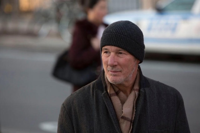 Gere standing on the street, embodying his character's struggle with homelessness during filming in New York