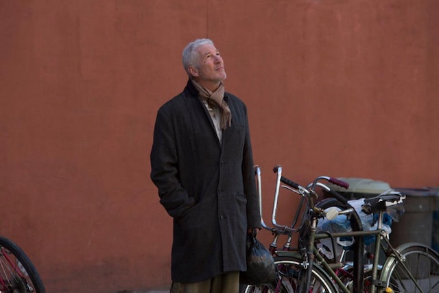 Gere looks up thoughtfully, showcasing a moment of vulnerability as he portrays a man facing extreme challenges