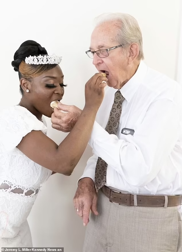 Miracle and Charles enjoying a sweet wedding moment, feeding each other cake on their special day