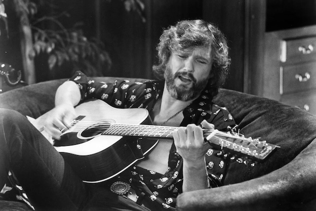 A dynamic shot of Kris Kristofferson playing guitar, reflecting his love for music and his deep connection to storytelling through song