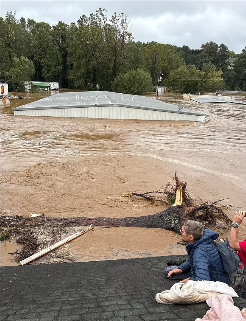 The floodwaters rose so high that young Micah, his mom Megan Drye, and her parents had to climb onto the roof of their home for safety, as seen in this photo. Moments later, the house gave way to the flood, tragically taking the lives of Micah and his grandparents.