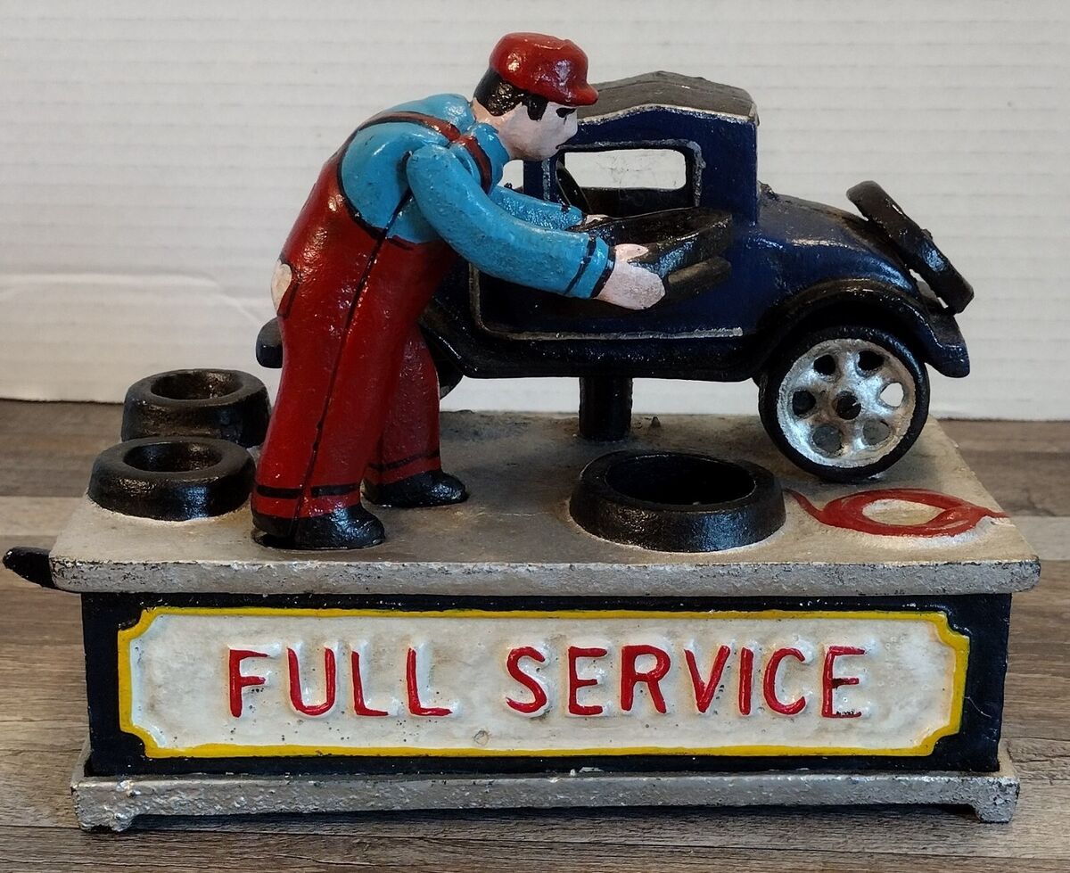 This restored cast iron coin bank from 1932 represents a slice of automotive history, as it beautifully depicts a mechanic working on a vintage car at a full-service station.