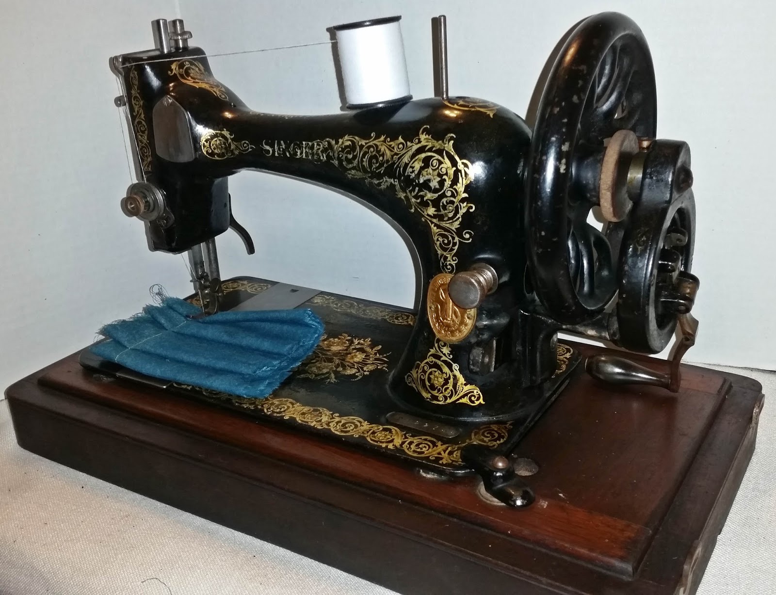 This beautifully restored 1894 Singer sewing machine, complete with its original treadle mechanism, is a functional piece of history ready for new creative projects.