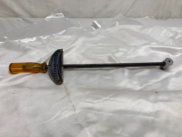 A well-preserved vintage beam torque wrench, showcasing its original amber handle and metal beam for exact torque readings