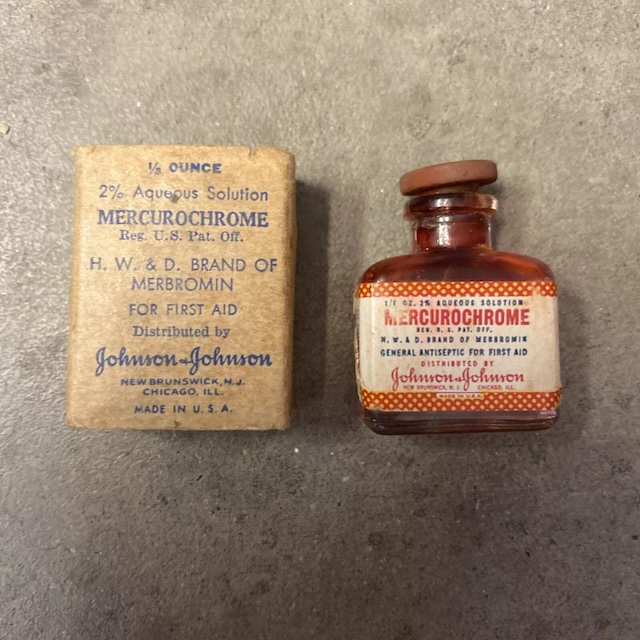 An unopened vintage bottle of Mercurochrome alongside its original packaging. This bottle displays the authenticity and age of a product that was once essential for first aid kits