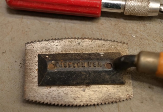 The worn blade of a vintage veneer saw, with "Made in USA" engraved, showcasing craftsmanship from another era