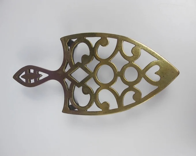 A classic brass trivet that evokes nostalgia - with its timeless design, it's hard not to think of its past uses in a cozy kitchen