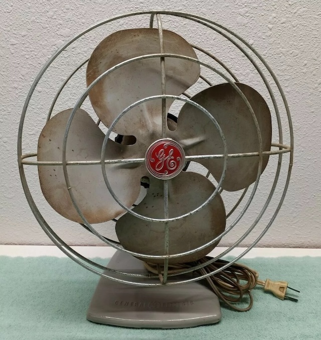 A well-used GE electric fan, displaying the wear and tear of years of service but still maintaining its iconic style