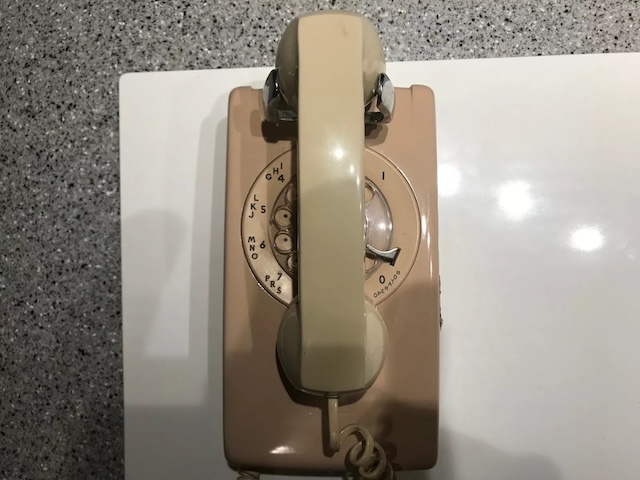 The sturdy construction of the vintage beige rotary phone ensured it was built to last, serving countless conversations over the decades