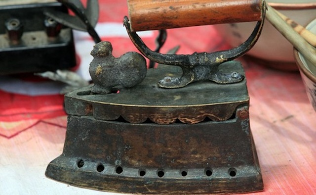 An antique coal iron with a unique bird-shaped latch – a design often seen in vintage models, adding character to this once-essential household tool