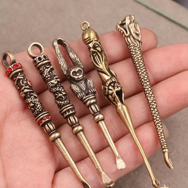 A collection of intricately designed vintage earwax removers, each featuring unique and ornate handles, reflecting both function and art