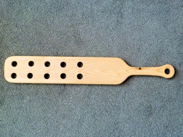 This beautifully crafted vintage wooden paddle shows how simplicity and functionality were key in its design, with air holes to increase its swiftness