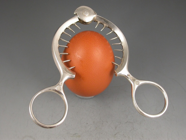 A closer look at the egg topper in action, effortlessly slicing through the top of a boiled egg with precision.