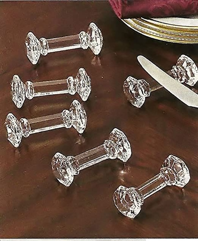 An elegant set of crystal knife rests on a fine dining table, perfectly complementing the silverware and inviting a sense of nostalgia