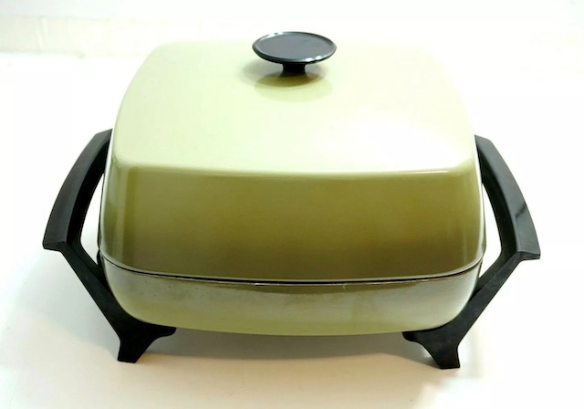 A side view of the vintage electric skillet, showing its sturdy handles. This piece was built to last, providing countless meals over the years