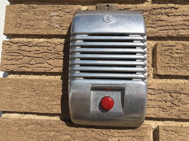 Mounted on a brick wall, this vintage drive-in speaker brings back memories of outdoor movie nights from decades past