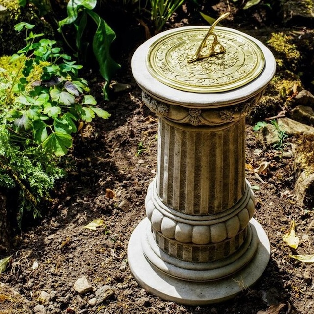 The sundial placed in a garden on a decorative pedestal. Such a timeless piece often stood as a symbol of wisdom and connection to the natural world