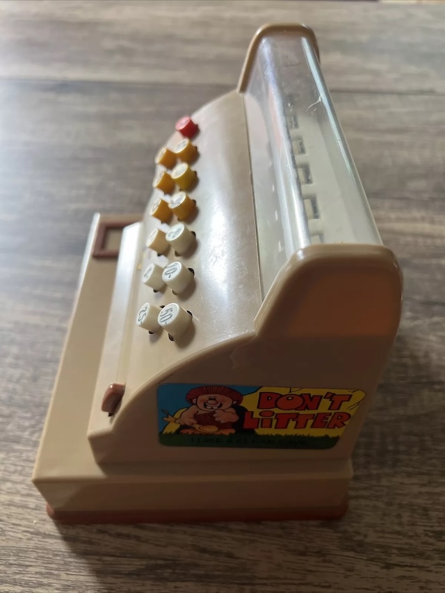 Side view of the Casdon cash register with a reminder for kids of the era: 'Don't Litter,' promoting responsibility even in play