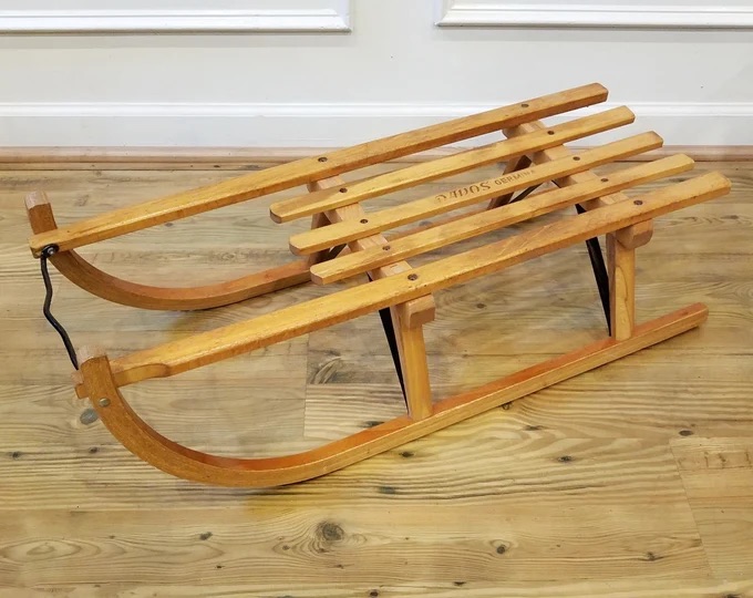 The craftsmanship of this sled speaks to an era when toys were built to last, evoking nostalgia for simpler times