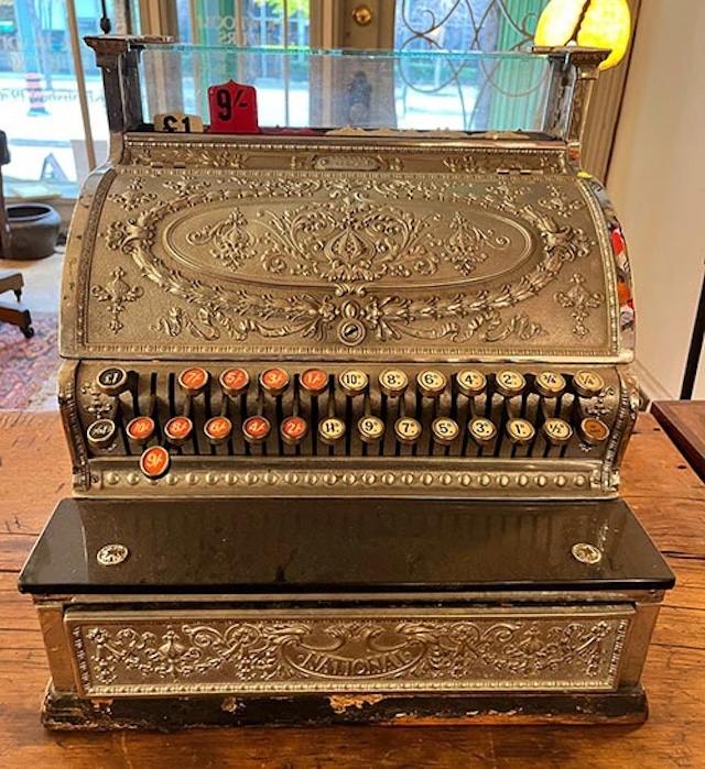 This vintage mechanical cash register still shines with its golden finish and elegant structure, evoking memories of the past when transactions were conducted with a charming mechanical click