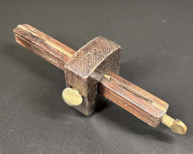 With its worn edges and rustic patina, this tool has likely seen decades of use in a carpenter's hands, marking countless lines on various projects