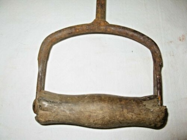 Close-up of the wooden handle of the antique hay hook, providing an ergonomic grip to make heavy lifting easier for workers of yesteryears