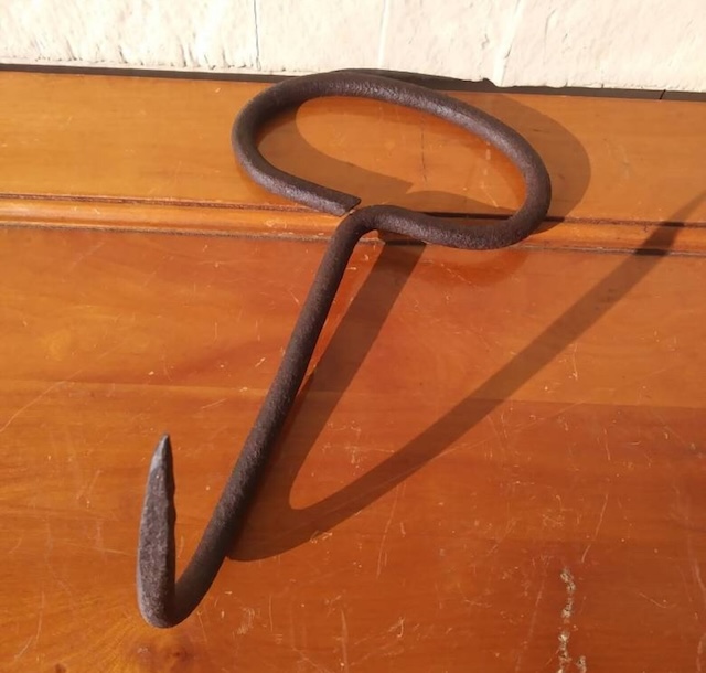 A uniquely shaped hay hook, used by farmers and workers during the heyday of manual labor on farms, this tool was a staple for moving hay efficiently