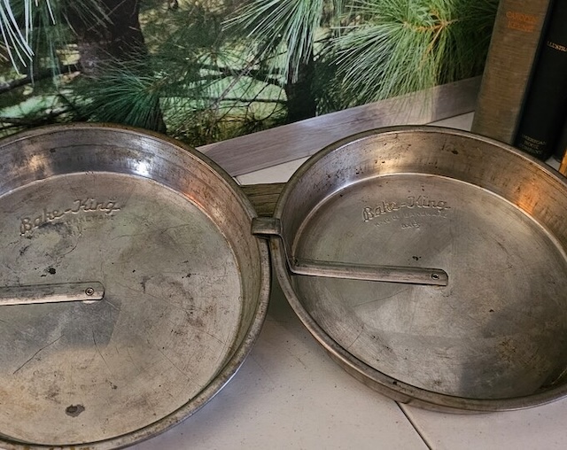 The sliding mechanism of the vintage cake pan in focus, showing how the arm would easily release baked goods