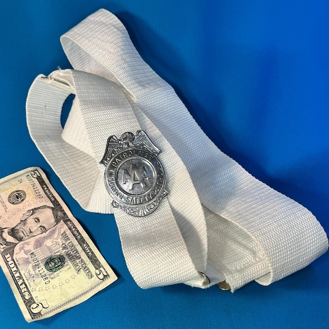 A closer look at the classic white school safety patrol belt and silver AAA badge, a symbol of responsibility in the hallways