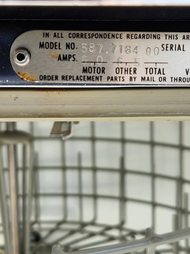 A close-up of the internal model number and components of a vintage Kenmore dishwasher, showing the craftsmanship of these durable appliances, which were built to last