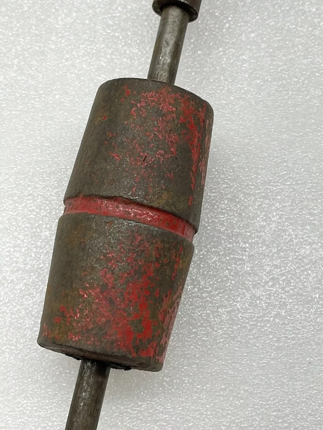 The rustic red paint on this vintage auto dent puller hints at years of use, bringing back memories of old-school car repair