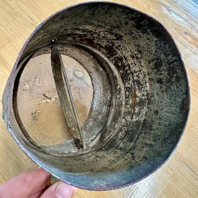 The inside of the flour sifter shows the mesh screen and rotating mechanism that helped aerate dry ingredients